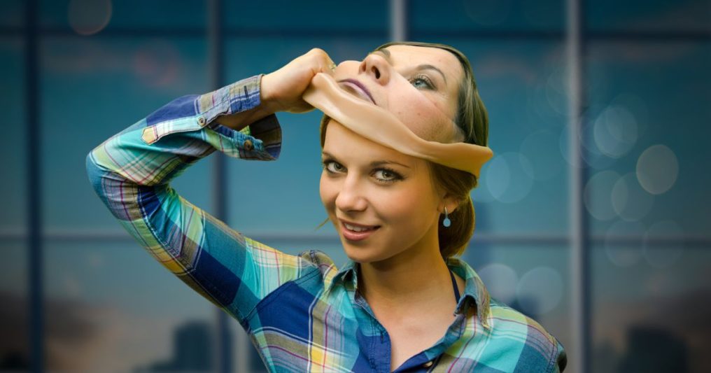 A woman pulls off a realistic-looking mask of her own face, revealing the same face underneath, with a sinister smile—symbolizing the deceptive nature of deepfakes and the risks they pose in real estate transactions.